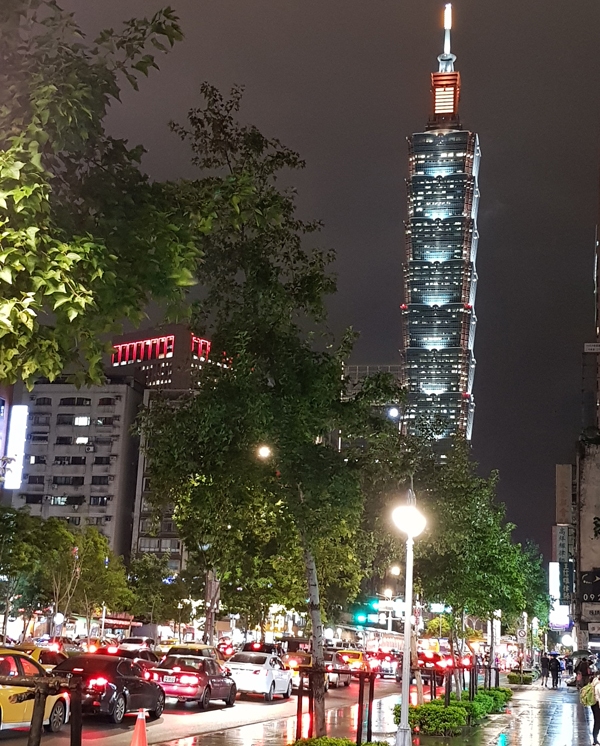 Taipei 101 towering in the distance, beautiful in the cold, wet night.